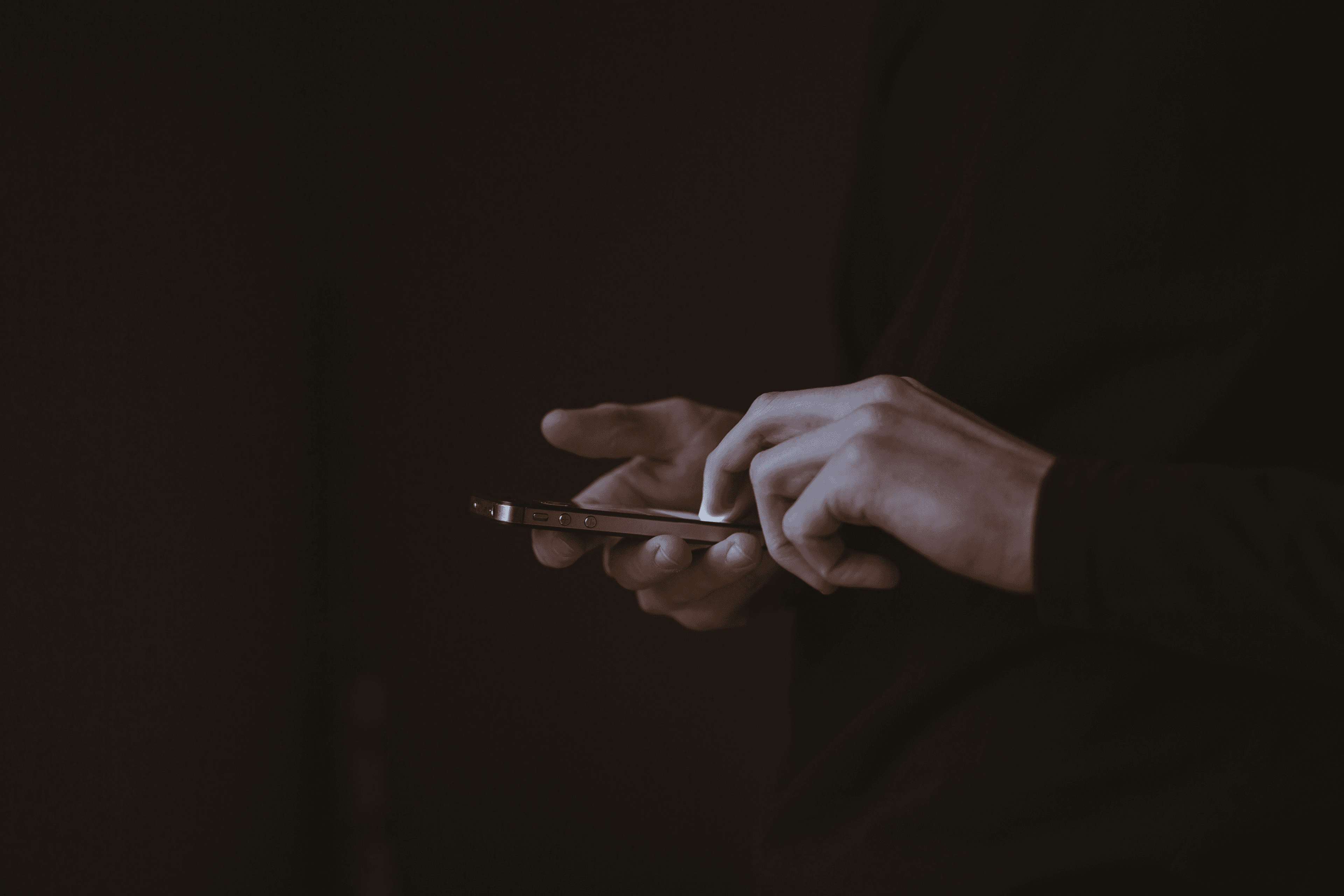 Hands with a phone in the dark